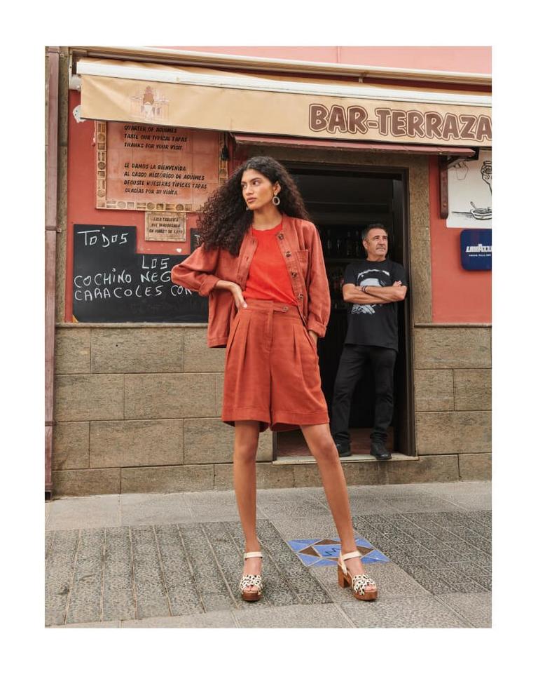 Woman wearing linen shorts standing in front of restaurant